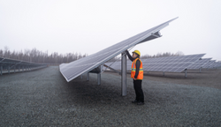 engineer-standing-under-community-solar-garden-panel